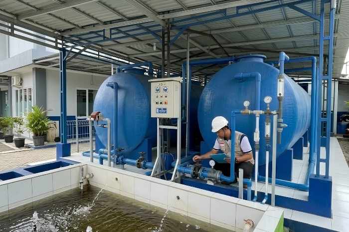 Instalasi IPAL compact di area klinik dengan tangki pengolahan, perpipaan dan panel kontrol